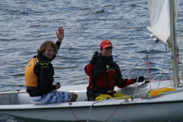 Two Adults sailing a dinghy sailboat